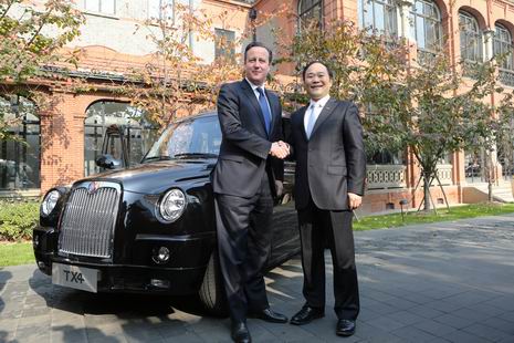 英国首相卡梅伦与金年会控股集团董事长李书福在伦敦经典黑色出租车前亲切握手。 